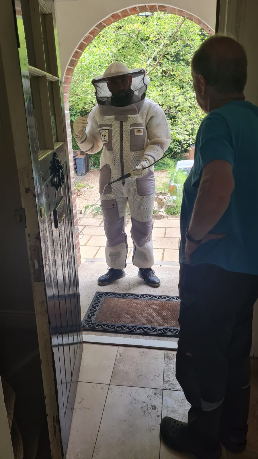 Adam in a protective suit at a customer's front door