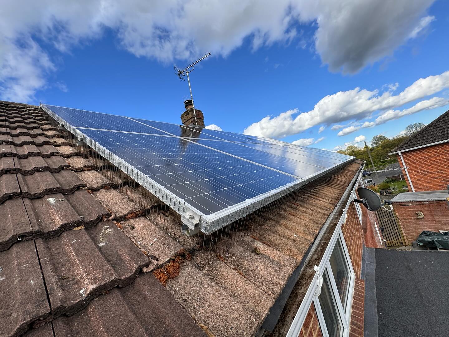A roof with solar panels, seen from the roofline